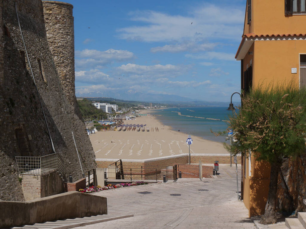 Ulica Montecastello z kolorowymi budynkami i morze w tle wzdłuż murów miasta Zamek Swabian w Termoli - Zdjęcie, obraz