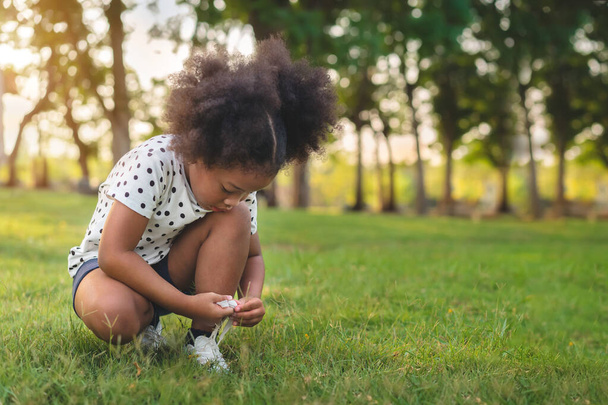 African little black girl prepare shoe before running at outdoors park. - Photo, image