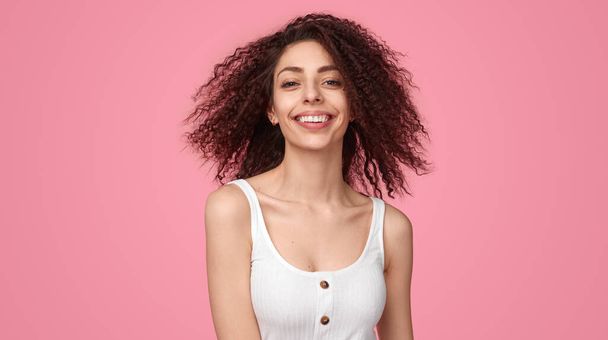 Cheerful woman with curly hair looking at camera - Φωτογραφία, εικόνα