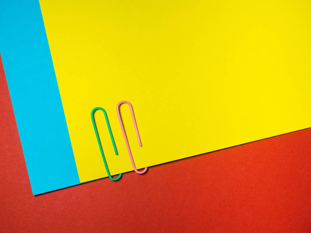 Colored paper clips on paper. Office supplies. Business goods. Colorful office supplies - Foto, Imagem