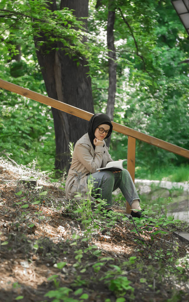 Μουσουλμάνα μελετάει τη διάλεξή της στο πάρκο - Φωτογραφία, εικόνα
