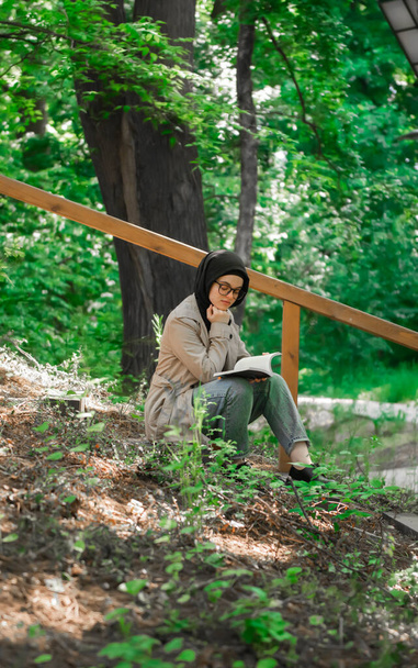 Muslim woman studying her lecture in the park - Фото, изображение