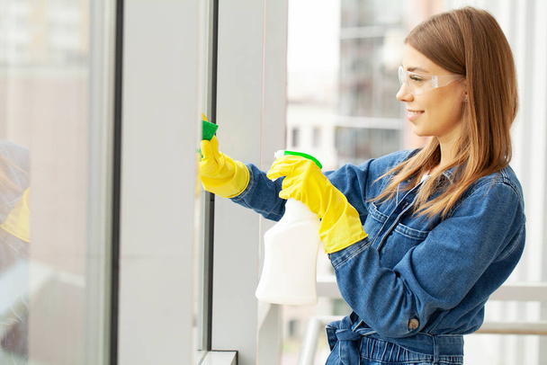 Pretty woman in uniform with supplies cleaning in office - 写真・画像