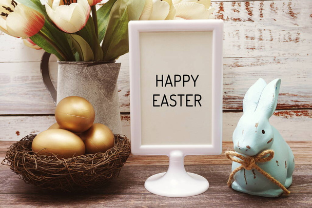Happy Easter with flower, rabbit and easter eggs decoration on wooden background - Foto, Imagen