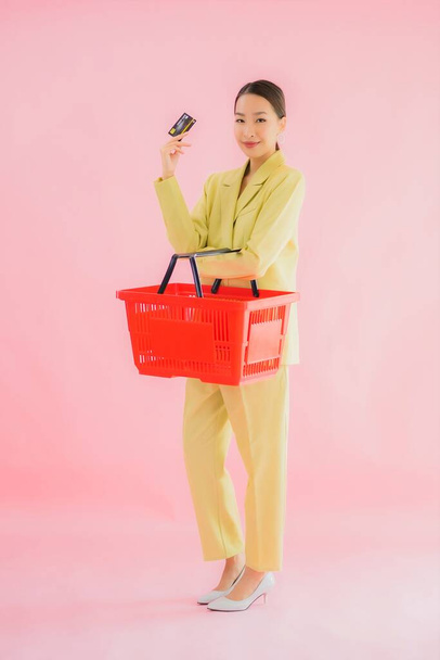 Портрет красива молода азіатка з продуктовим кошиком з супермаркету на кольоровому фоні
 - Фото, зображення