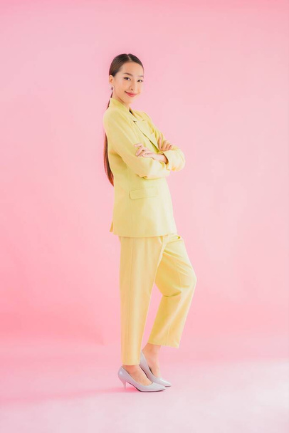 Portrét krásné mladé asijské obchodní žena úsměv v akci na růžovém pozadí - Fotografie, Obrázek