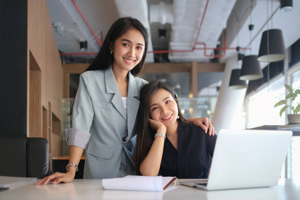 Two beautiful asian businesswoman working together in modern office and smiling to camera. - Fotoğraf, Görsel