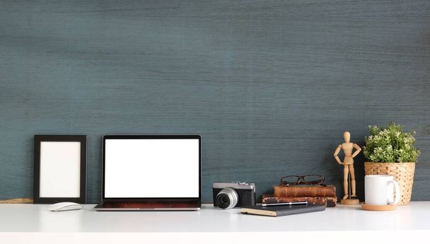 Mockup computer laptop, empty frame, camera and houseplant on white table. - 写真・画像