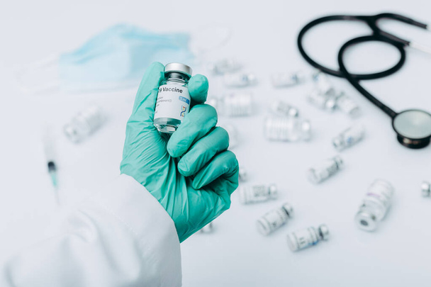 Рука вченого або лікаря, який тримає пляшку вакцини проти COVID-19, готується до введення в людей
. - Фото, зображення
