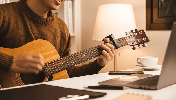 Young businessman sitting and playing guitar in office, relaxing and enjoy concept. - Foto, immagini