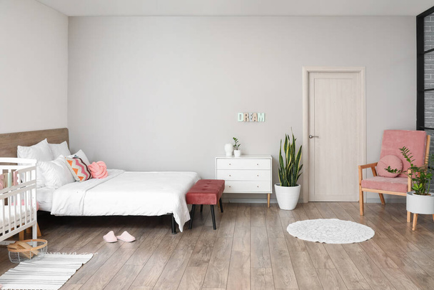 Интерьер стильной светлой спальни с детской кроваткой - Фото, изображение