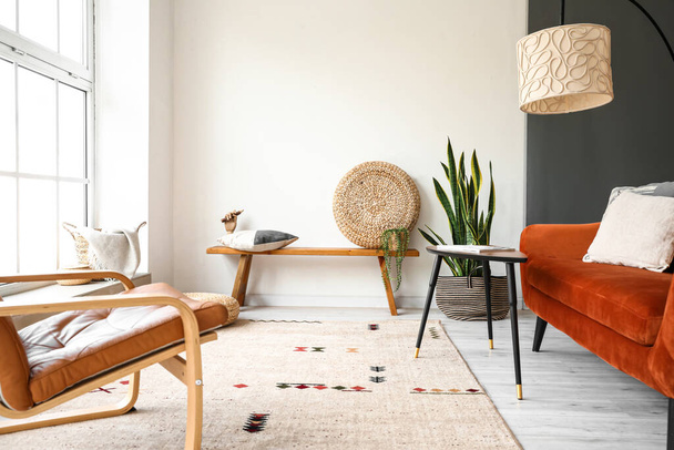 Moderní lavice s váčkem, polštářem a dřevěnou rukou v interiéru světlého obývacího pokoje - Fotografie, Obrázek