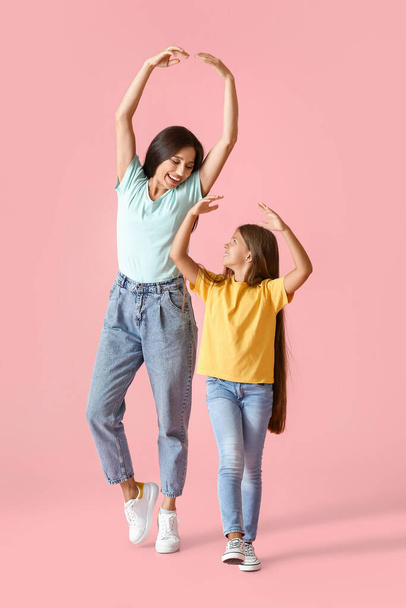 Happy dancing woman and her daughter on color background - Foto, imagen