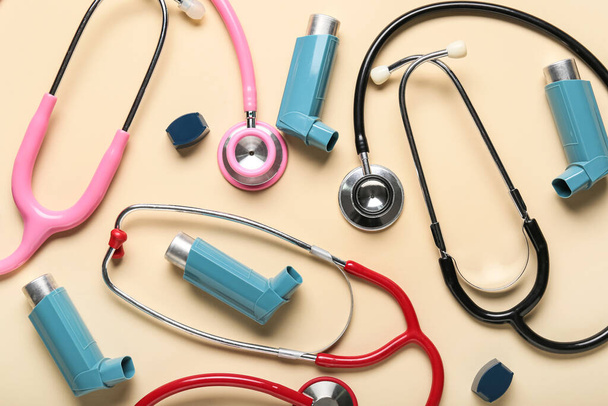 Asthma inhalers and stethoscopes on beige background - Fotó, kép