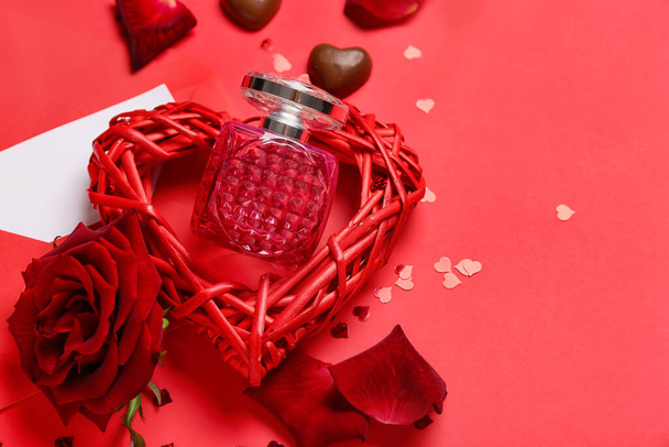 Άρωμα, καραμέλες σοκολάτας και τριαντάφυλλο για την ημέρα του Αγίου Βαλεντίνου σε κόκκινο φόντο, closeup - Φωτογραφία, εικόνα