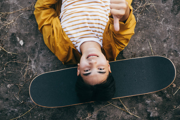 Teenager playing skateboard at cement ground, extreme sport and outdoor activity. - Zdjęcie, obraz