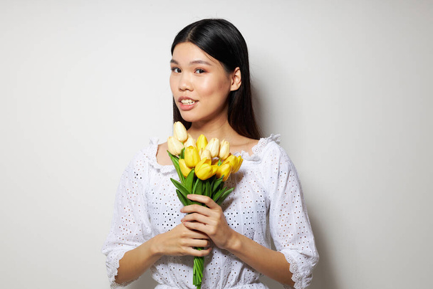woman with a bouquet of flowers smile close-up light background unaltered - 写真・画像
