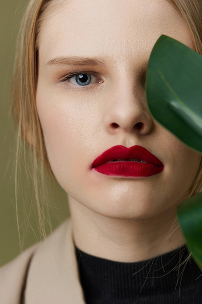 mujer con maquillaje brillante labios rojos hoja de palma - Foto, imagen