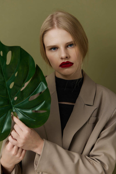 pretty woman green palm leaf coat bright makeup Lifestyle posing - Zdjęcie, obraz