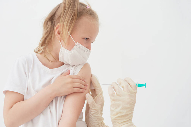 Une petite fille a peur des vaccins, des injections et des vaccinations. L'enfant est vacciné contre le coronavirus - Photo, image