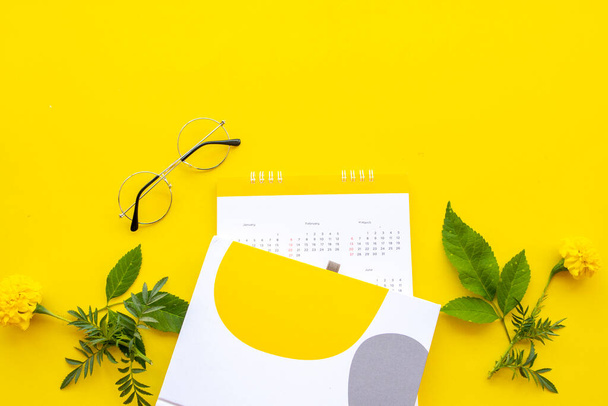 notebook, agenda planner voor zakelijke werk arrangement plat lay stijl op achtergrond geel - Foto, afbeelding