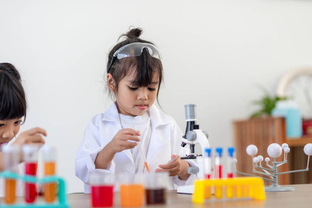 educación, ciencia, química y concepto de niños: niños o estudiantes con un experimento de fabricación de tubos de ensayo en el laboratorio escolar
 - Foto, Imagen