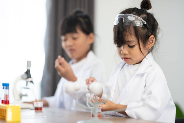 educación, ciencia, química y concepto de niños: niños o estudiantes con un experimento de fabricación de tubos de ensayo en el laboratorio escolar
 - Foto, imagen