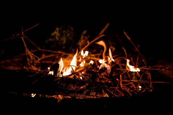 fire and flames. Flames and burning sparks close up, fire patterns. flames from the fire. Night bonfire, logs are on fire, sparks fly. soft focus.shallow focus effect. - Foto, Imagem