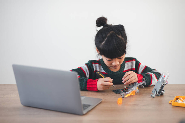 Inventive kid constructing robot cars at home - 写真・画像