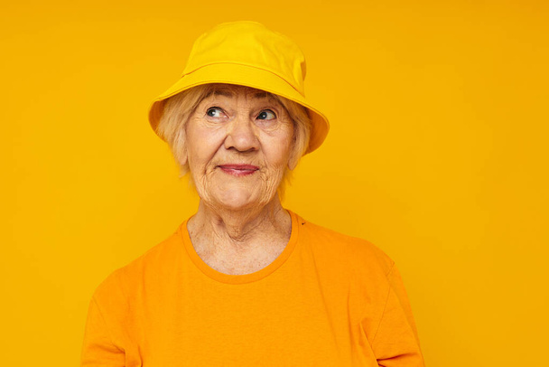 Portrait of an old friendly woman happy lifestyle in a yellow headdress close-up emotions - Foto, Bild