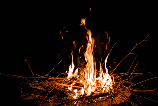 fire and flames. Flames and burning sparks close up, fire patterns. flames from the fire. Night bonfire, logs are on fire, sparks fly. soft focus.shallow focus effect. - Foto, Bild