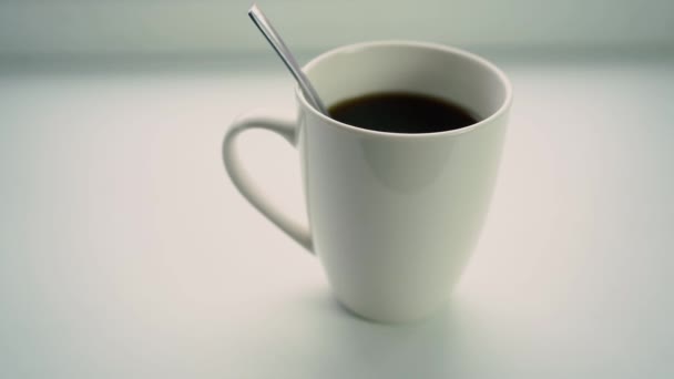 Μια κούπα καφέ δίπλα στο παράθυρο στο περβάζι του παραθύρου - Πλάνα, βίντεο