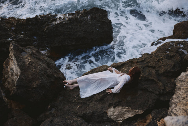 Femme pieds nus en robe de mariée blanche sur le rivage de la mer vue sur les cheveux mouillés d'en haut - Photo, image