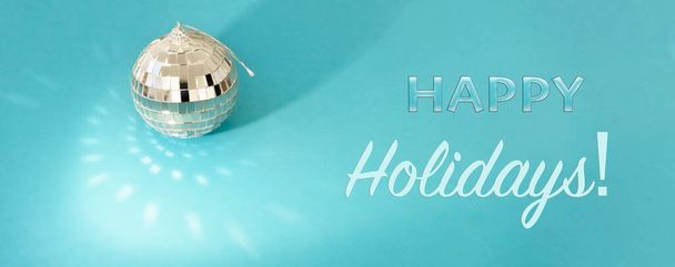 Happy Holidays text. Disco ball on a blue background, glare, light, sun bunnies - Fotoğraf, Görsel