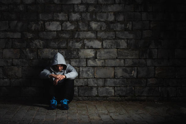 Depressed teenager wearing a hoodie - Photo, image