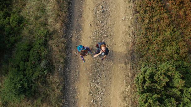 Couple exploring woods road aerial scene young people enjoying nature land - 写真・画像