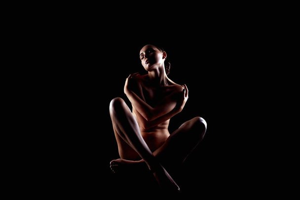 Silhouette femme nue dans le noir. belle nu corps fille - Photo, image