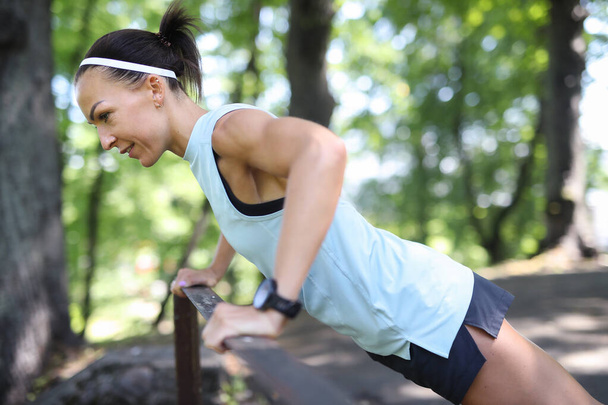 Sportovní a zdravý životní styl. Mladá žena cvičení v parku - Fotografie, Obrázek