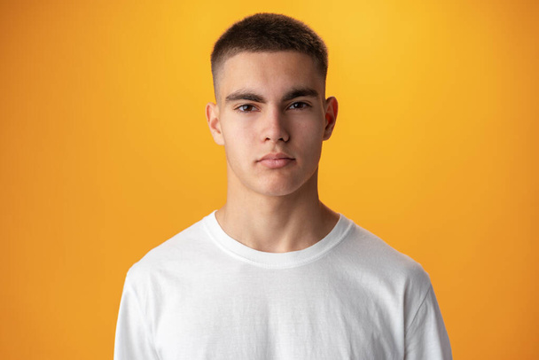 Portrait of a teen boy smiling against yellow background - Foto, immagini