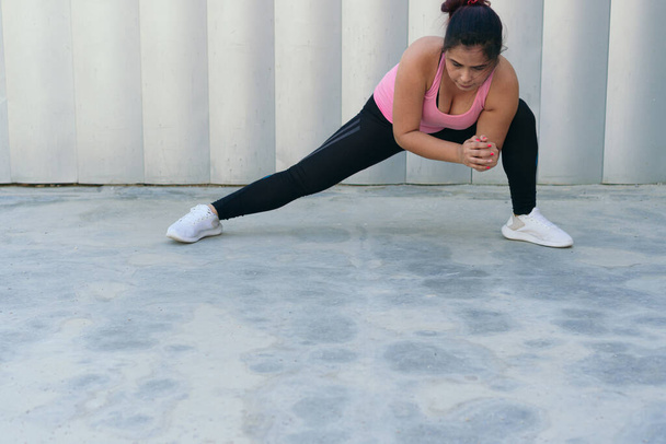 Atleta latina haciendo ejercicio de estiramiento en parque - Foto, Imagen