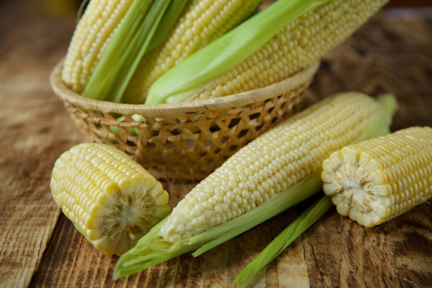 The young cobs of fresh yellow corn on the background of wooden table. Harvest from the organic garden. - Fotografie, Obrázek