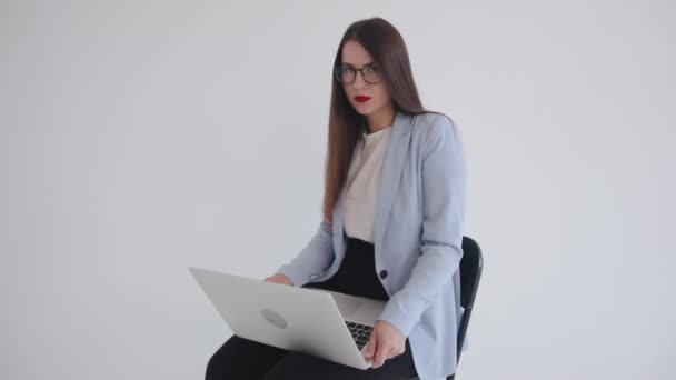 Jonge succesvolle zakenvrouw werkt aan een laptop en kijkt glimlachend naar de camera. Leider en professioneel concept - Video