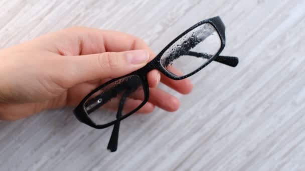 Pulizia di un paio di occhiali da vista sporchi con una microfibra. - Filmati, video