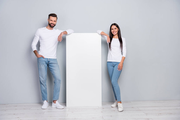 Full length body size view of attractive cheerful couple demonstrating copy space poster isolated over grey pastel color background. - 写真・画像