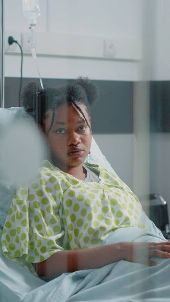 病院病棟に座っているアフリカ系アメリカ人女性の肖像 - 写真・画像