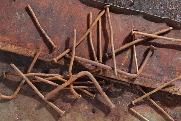 Old rusting nails on a grunge metal background, top view - Photo, Image