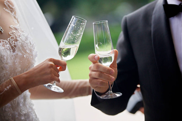 Egy pohár alkoholos ital két szerető kezében. A koncepció az ünnepek és bankett szórakoztató. - Fotó, kép