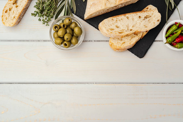 Italian ciabatta bread with olive oil on wooden background - Photo, Image