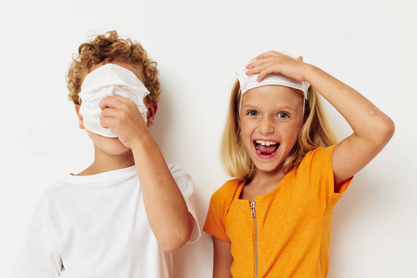 Boy and girl in a medical mask fun isolated background unaltered - Foto, Imagem