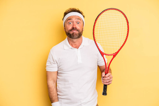 middle age man shrugging, feeling confused and uncertain. tennis concept - Photo, Image